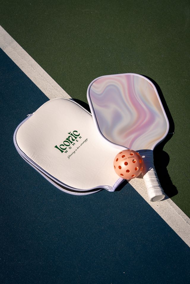 colorful pickleball paddle and ball on a green and blue court